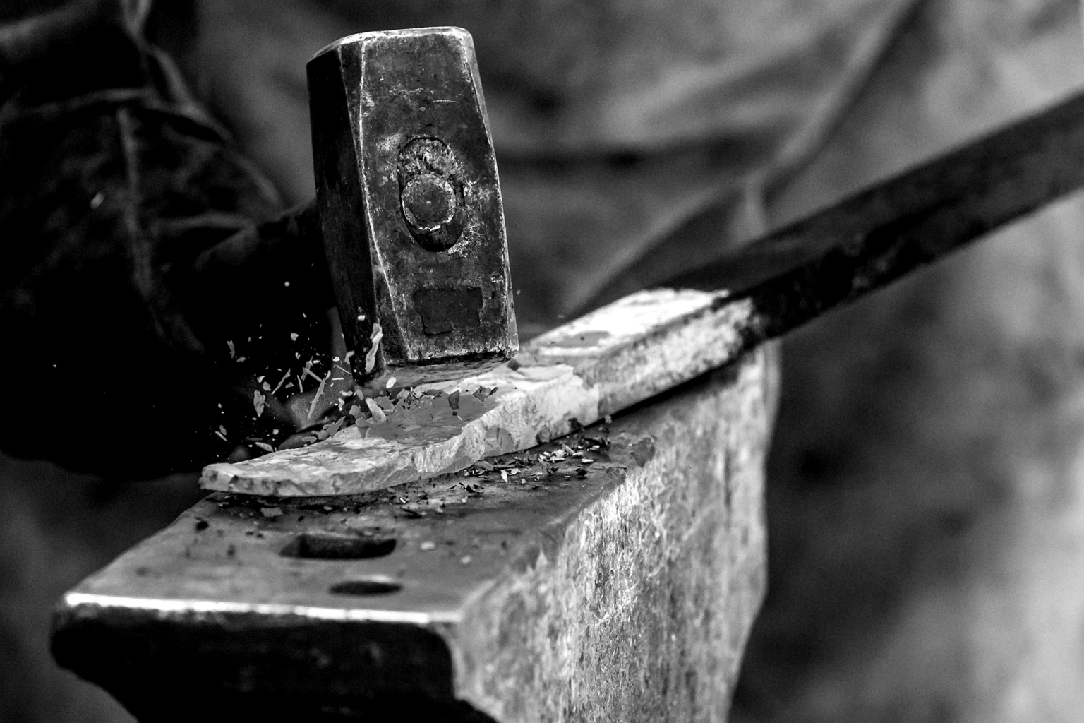 Hammer forging steal on an anvil black and white photo