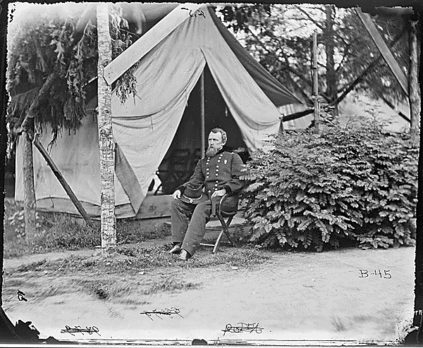 Black and white photo of a civil war general outside of his tent.