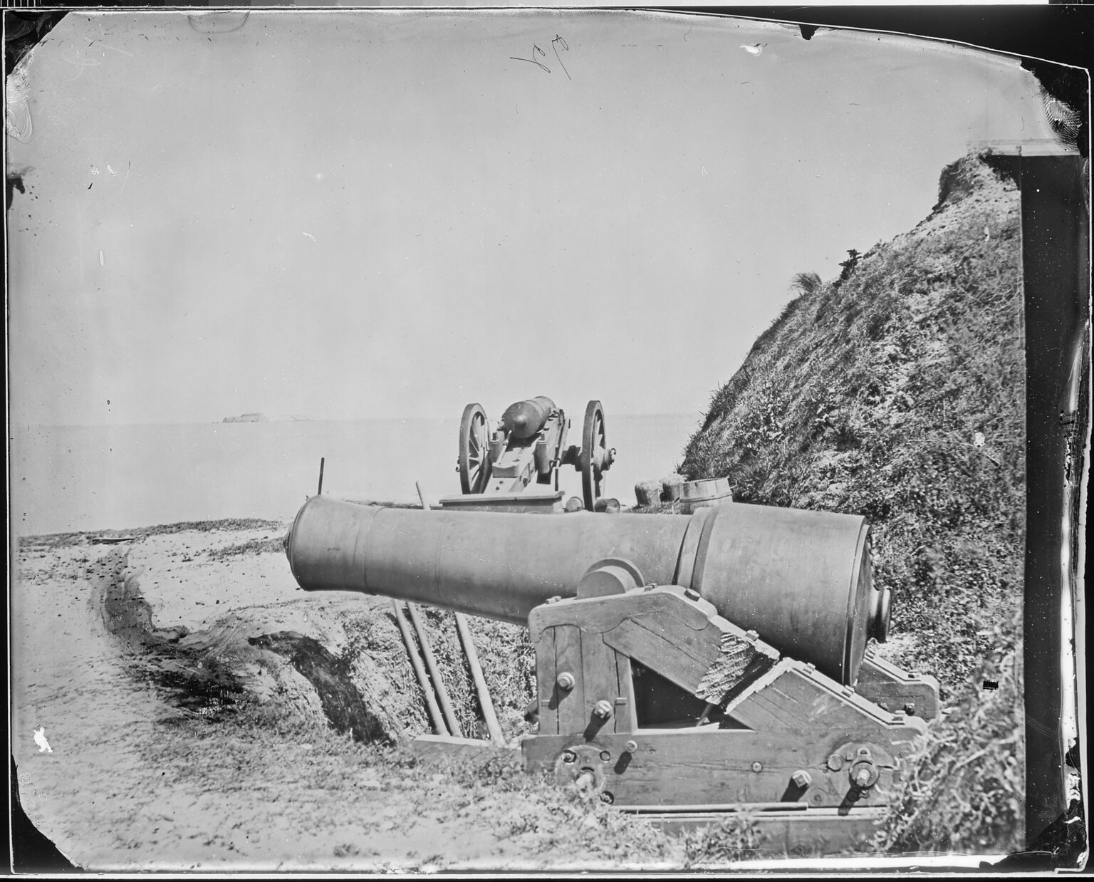 Black and white photo of old cannons at an army fort.