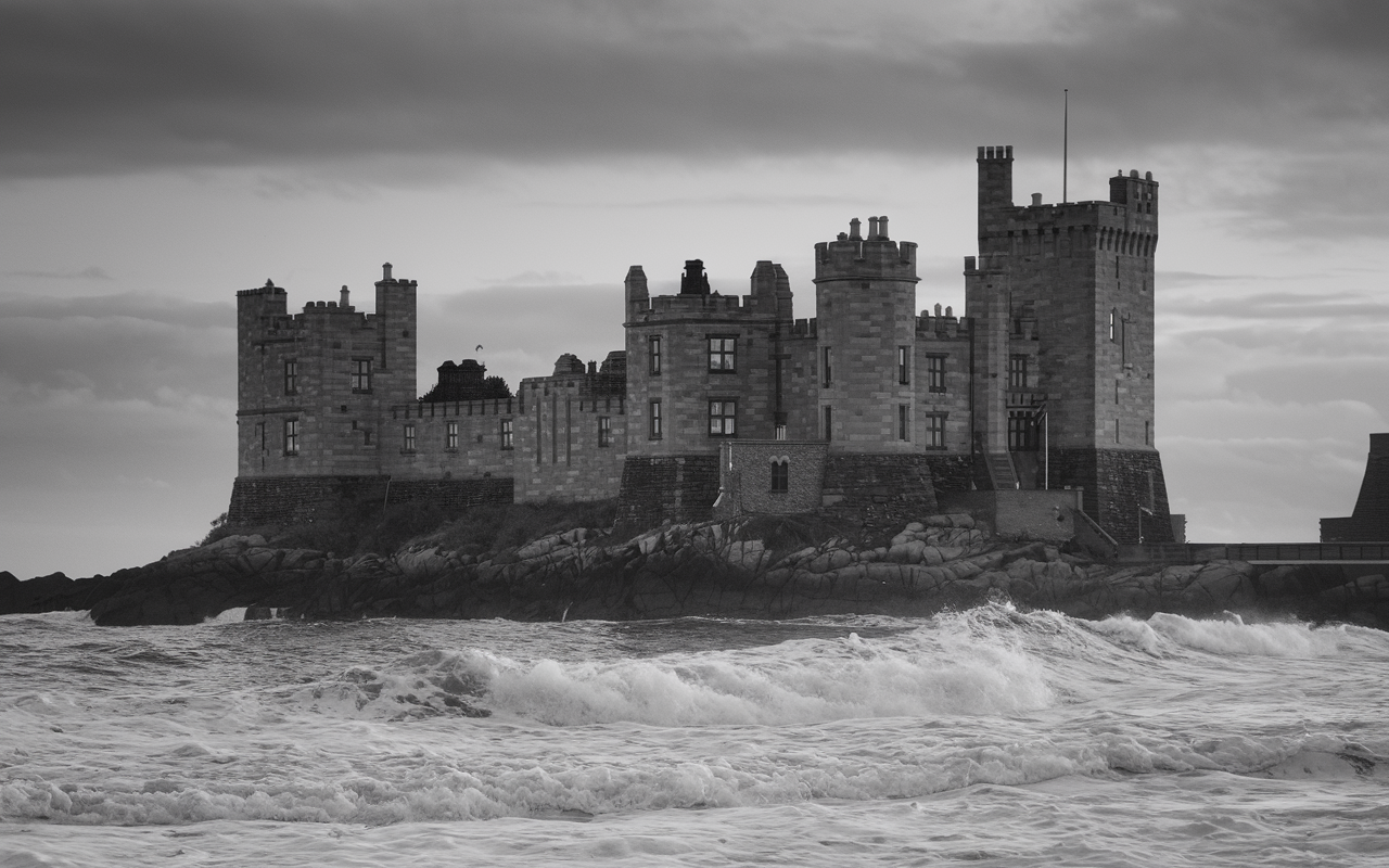 Black and white photo of a castle on the sea side.